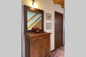 a hallway with a mirror and a wooden dresser at Residenza Fornaro in Premolo