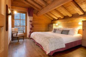 a bedroom with a bed in a wooden room at Madame Vacances Le Chalet Arosa in Le Joseray
