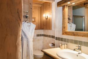 ヴァル・ディゼールにあるMadame Vacances Le Chalet Arosaの洗面台、トイレ、鏡のあるバスルーム
