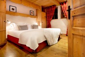 1 dormitorio con 1 cama grande en una habitación en Madame Vacances Le Chalet Arosa en Le Joseray