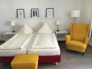 a bedroom with a bed and a chair at Wohnen am Schloss, Herzog in Sondershausen