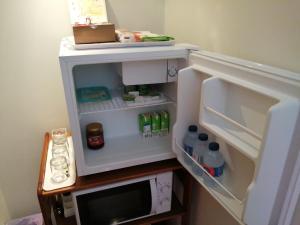 a small refrigerator with its door open and food inside at VianasHome in Amarante