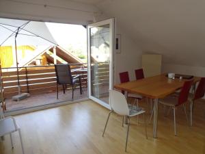 a dining room with a table and chairs and a balcony at SOLADOM in Efringen-Kirchen