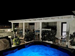 - une piscine en face d'une maison la nuit dans l'établissement B&B Le Tartarughe, à San Vito Lo Capo