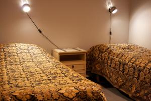 two beds in a room with two lights on the wall at Gasthaus Punkaharju in Punkaharju