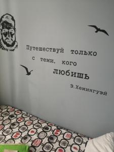 Un dormitorio con una pared con escritura. en Mom, I'm Home, en San Petersburgo