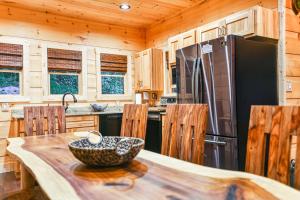 a kitchen with a table and a refrigerator at The Grand Fir in Gatlinburg