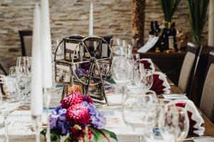 einen langen Tisch mit Brille und Blumen darauf in der Unterkunft Hotel & Restaurant Hessischer Hof in Hainburg