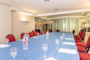 a conference room with a long table and red chairs at Hotel Abades Manzanil in Loja