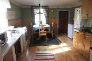 a kitchen with a table and a dining room at Charmig hallandslänga nära Ullared in Ullared