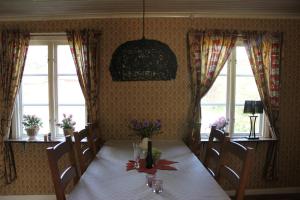 Charmig hallandslänga nära Ullared في أولاريد: غرفة طعام مع طاولة مع الزهور عليها