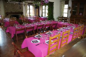 une salle à manger avec des tables et des chaises roses dans l'établissement Gîte El Tyû, à Écaussinnes-dʼEnghien