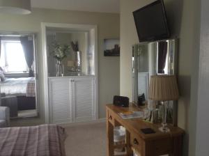a bedroom with a bed and a desk with a television at 3 Braehead in Thurso
