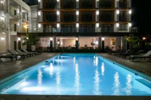 a swimming pool in front of a building at night at Aquamarine Family Club in Gagra