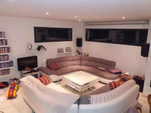 a living room with a couch and a table at Chambres, cuisine, piscine, spa, billards, airhockey, nature in Fillinges