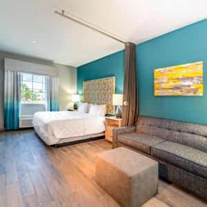 een slaapkamer met een bed en een bank bij Everglades Adventures Hotel Suites by Ivey House in Everglades City