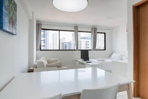 un salon blanc avec une table et des chaises blanches dans l'établissement Conforto e praticidade em Boa Viagem., à Récife