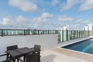 d'un balcon avec une table et des chaises, ainsi que d'une piscine. dans l'établissement Conforto e praticidade em Boa Viagem., à Récife