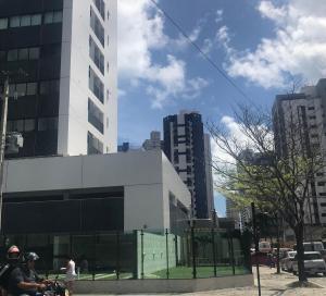 two people on a motorcycle in front of a building at Conforto e praticidade em Boa Viagem. in Recife