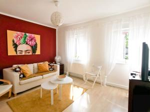 a living room with a white couch and a red wall at Dream Green Apartment 'Frida' in Gladenbach