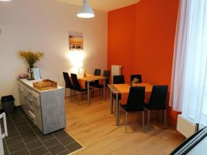 uma sala de jantar com mesas e cadeiras e paredes cor de laranja em Pension zum Spitz em Seebenstein