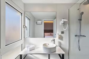 Un baño blanco con lavabo y ducha. en B&B HOTEL Tarragona Centro Urbis, en Tarragona