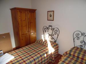 1 dormitorio con 2 camas y armario de madera en CASA PATRIZIA MONTAIONE, en Montaione