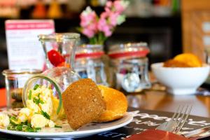 a table with a plate of food on a table at Ramada by Wyndham München Airport in Oberding