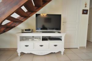 a white dresser with a tv on top of it at Gîte de Catherine in Saint-Didier