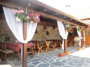 een patio met een tafel, stoelen en bloemen bij Guest House Popov in Marchevo