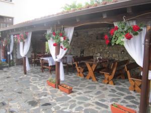 a patio with a table and chairs and flowers at Guest House Popov in Marchevo