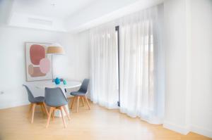 un comedor blanco con mesa y sillas en Casas del Mar Boutique, en Casares