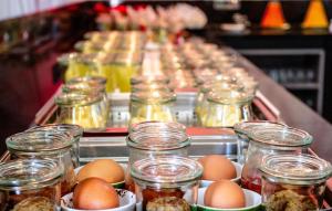 a table with jars of eggs and jars of food at Ramada by Wyndham München Airport in Oberding