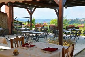 a restaurant with tables and chairs on a patio at Da Fabiana, Ristorante e Camere in Alta Langa - adults only in Bossolasco