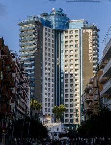 
a tall building with a clock on it's side at Hotel Madeira Centro in Benidorm
