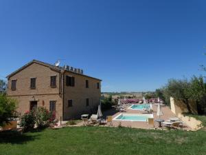 a building with a swimming pool next to a house at Il Giardino Degli Ulivi in Appignano