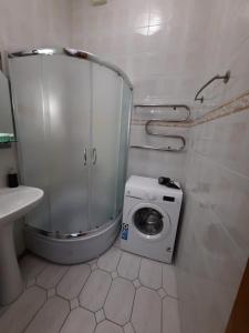 La salle de bains est pourvue d'un lave-linge et d'un lavabo. dans l'établissement Apartment Arena City, à Kiev