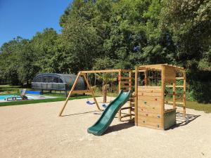 a playground with a slide and a play structure at Gîtes de Maner Ster - Le Frêne Piscine ou Le Chêne Piscine et Spa privatif in Cléden-Poher