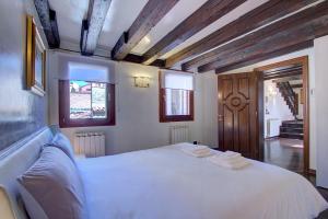 una camera da letto con un grande letto bianco e soffitti in legno di Marcopolo-Terrace a Venezia