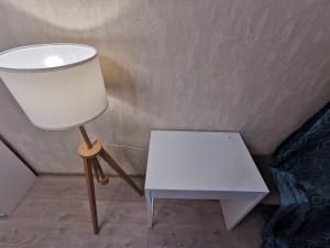 a white lamp and a white table in a room at Комфортабельные апартаменты. Добро пожаловать! in Tver