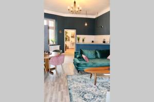ein Wohnzimmer mit einem grünen Sofa und einem Tisch in der Unterkunft Villa Rumpel aus Alt mach Neu in Beeskow