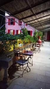 a patio with tables and chairs and a building at Hôtel Les Orangers in Hyères