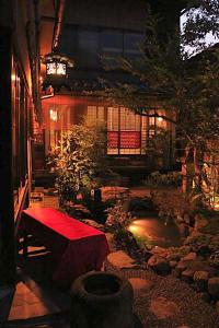 um jardim com um banco vermelho e um lago em Gionkoh em Quioto