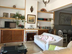 sala de estar con sofá blanco y chimenea en Casa Cary, en Santiago de la Ribera