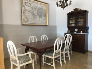 comedor con mesa de madera y 4 sillas en Casa Cary, en Santiago de la Ribera