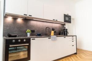 a kitchen with white cabinets and a stove at Apartment Erdberg I contactless check-in in Vienna