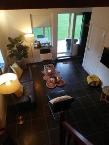 a living room with a couch and a table at Vakantiehuis Idylle aan Zee, privé SAUNA in Sint Maartensvlotbrug +10 photos