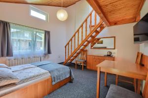 sypialnia z łóżkiem i drewnianymi schodami w obiekcie Willa Mak w mieście Krynica Zdrój