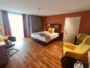 ein Hotelzimmer mit einem Bett und einem Stuhl in der Unterkunft H23 Hotel Stuttgart in Stuttgart