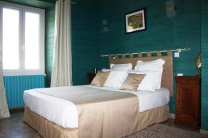 - une chambre avec un grand lit aux murs verts dans l'établissement Relais de La Ganache, à Saint-Astier